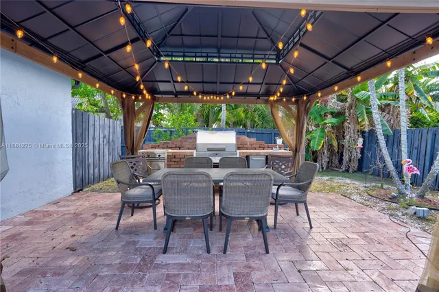 a view of a patio with table and chairs under an umbrella