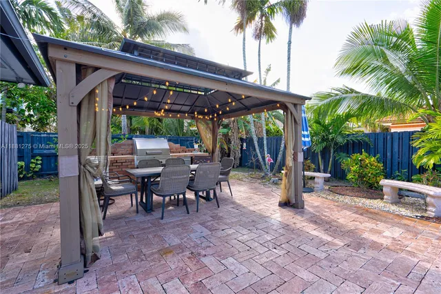 a living room with patio furniture and a potted plant