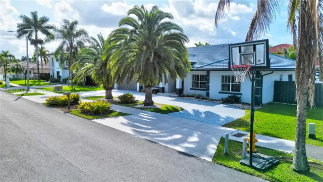 a row of palm trees in front of a house