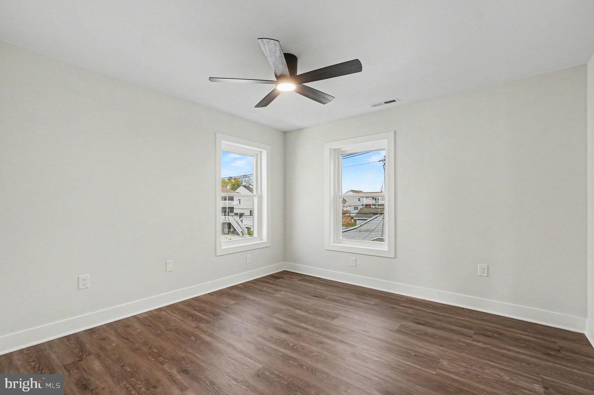 9108 Hinton Avenue Sparrows Point, MD 21219 - Photo 51 of 86 an empty room with wooden floor ceiling fan and windows