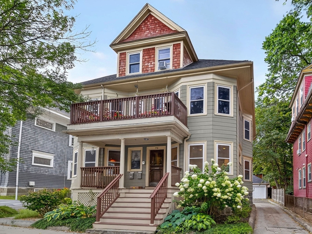 a front view of a house with a yard and potted plants