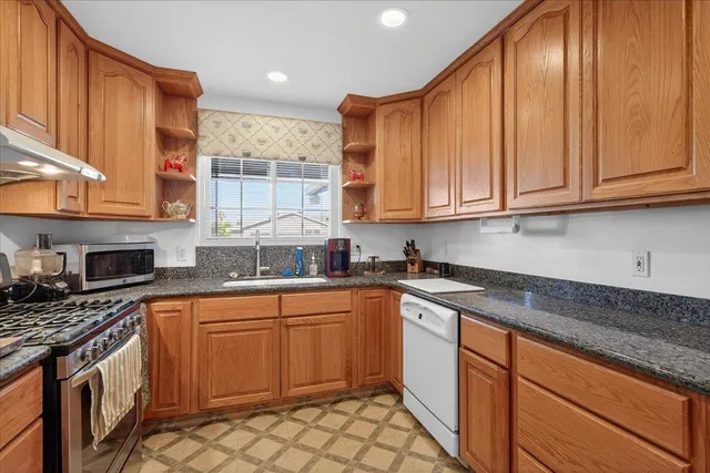 a kitchen with stainless steel appliances granite countertop a sink stove and cabinets