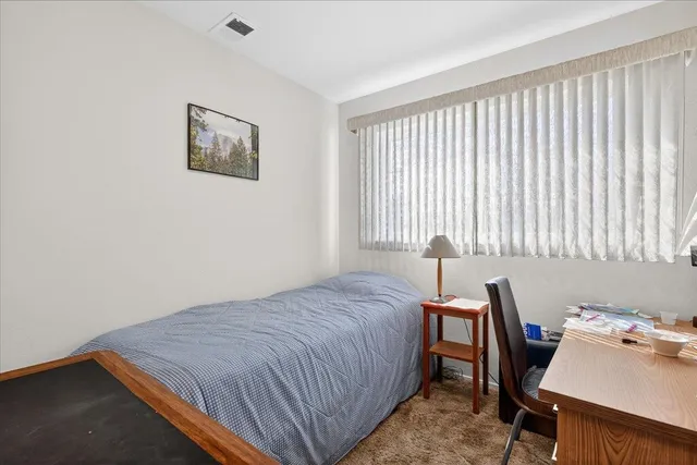 a bed sitting in a bedroom next to a window