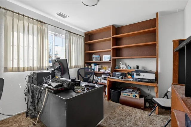 a view of a workspace with furniture and a window