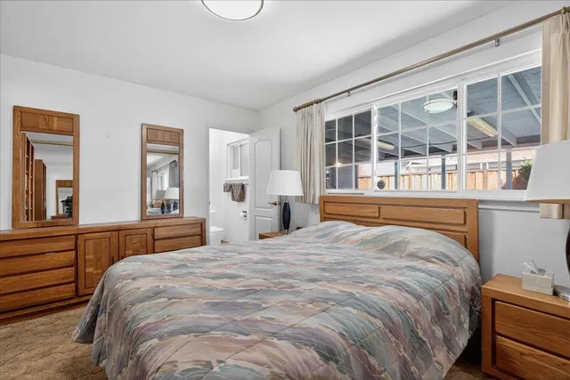 a bedroom with a bed and a large window