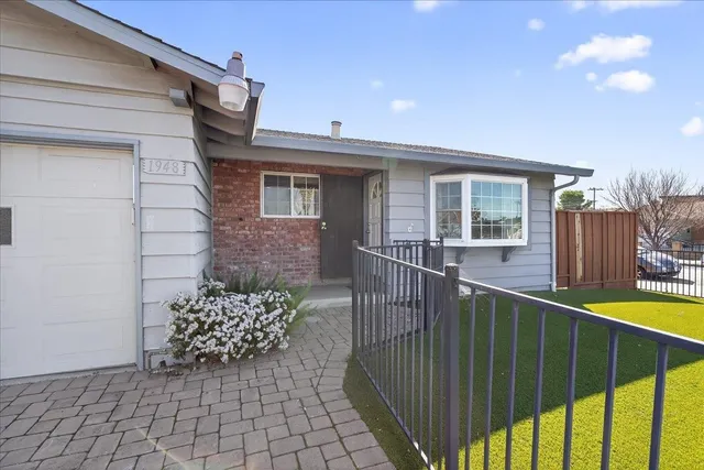 a view of a house with a small yard and wooden fence