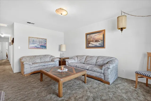 a living room with furniture a rug and a painting on the wall