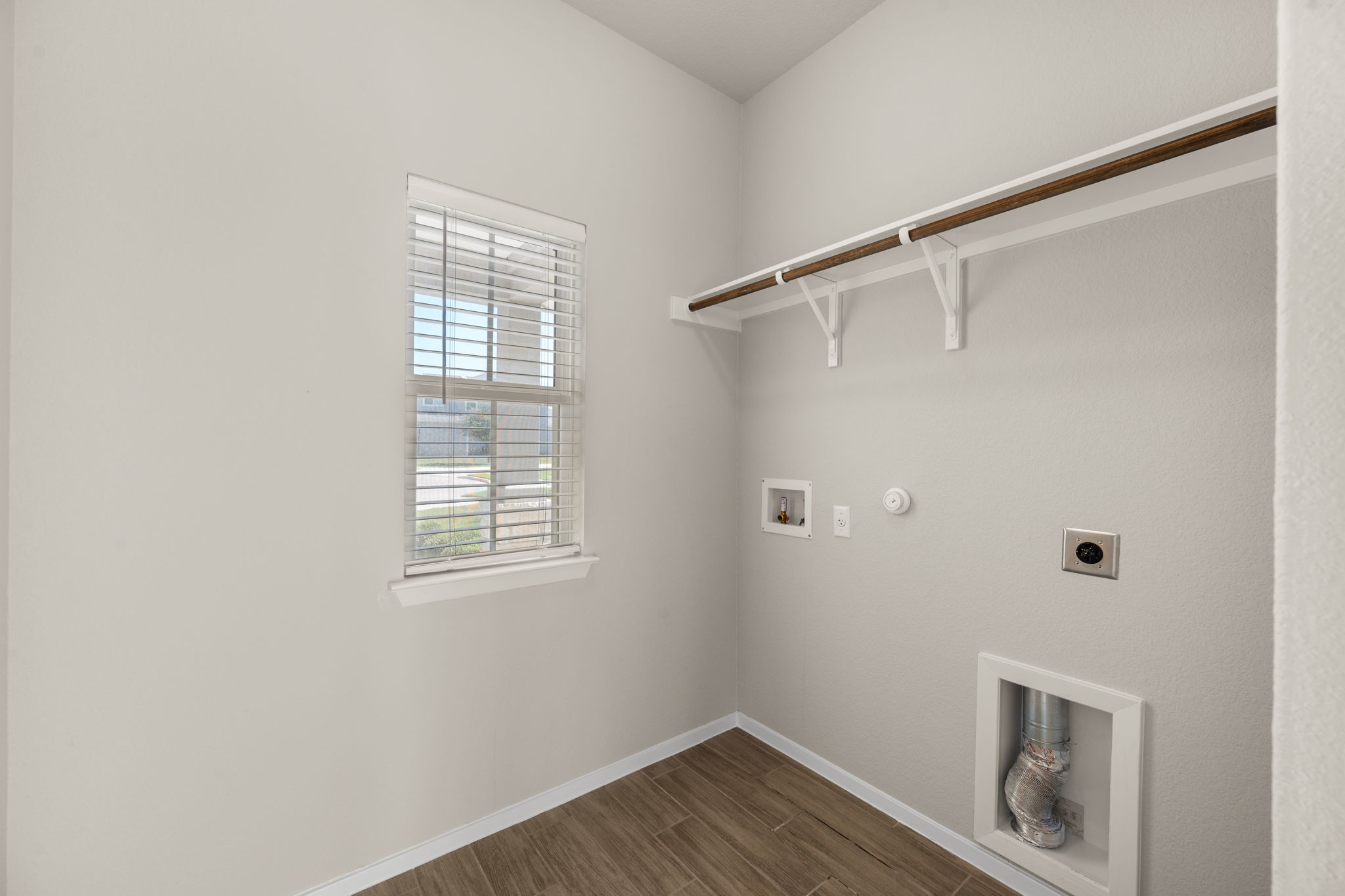 215 Lake Placid Run Elgin, TX 78621 - Photo 11 of 29 Functional utility room features wood-look tile flooring and a built-in hanging rod.