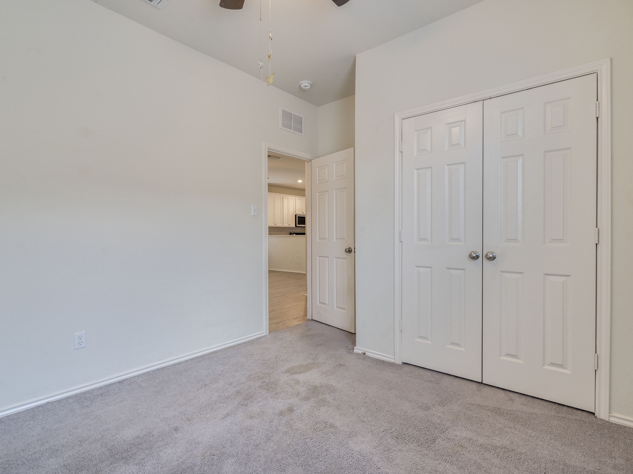 790 Pepperbark Loop Buda, TX 78610 - Photo 13 of 22 Comfortable carpeted bedroom featuring ample closet space and access to a bright kitchen.
