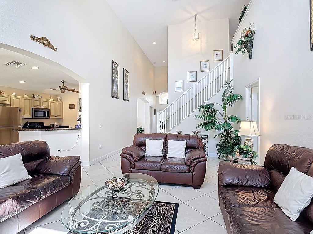 955 Lake Berkley Drive Kissimmee, FL 34746 - Photo 11 of 57 a living room with furniture and a chandelier