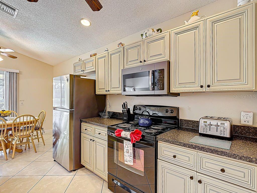 955 Lake Berkley Drive Kissimmee, FL 34746 - Photo 12 of 57 a kitchen with stainless steel appliances granite countertop a refrigerator sink and stove