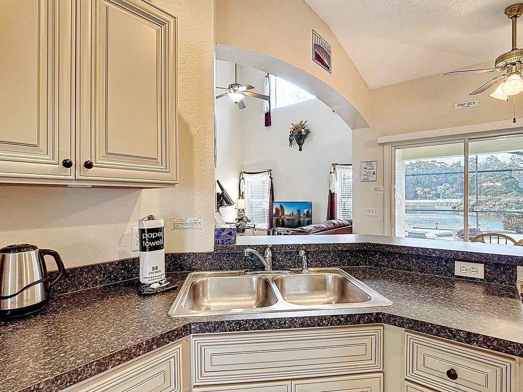 955 Lake Berkley Drive Kissimmee, FL 34746 - Photo 14 of 57 a kitchen with granite countertop a sink a window and cabinets