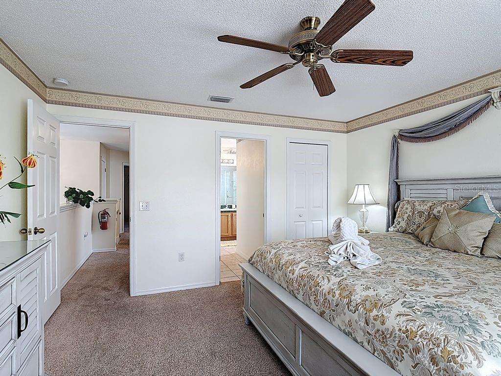 955 Lake Berkley Drive Kissimmee, FL 34746 - Photo 25 of 57 a bedroom with a large bed and a chandelier