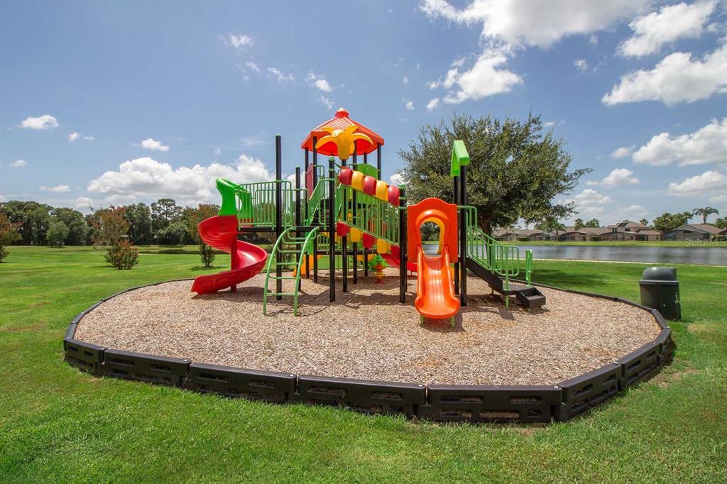 955 Lake Berkley Drive Kissimmee, FL 34746 - Photo 57 of 57 a childrens park with lots of swings slides and swimming pool in the back