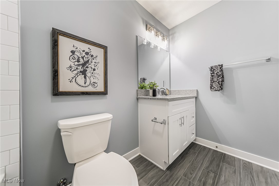 1240 Dorsh Road Cleveland, OH 44121 - Photo 15 of 36 Main floor bathroom featuring ceramic tiled floor, toilet, and vanity