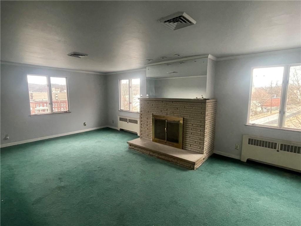 701 Thompson Avenue Donora, PA 15033 - Photo 14 of 36 an empty room with a fireplace and windows