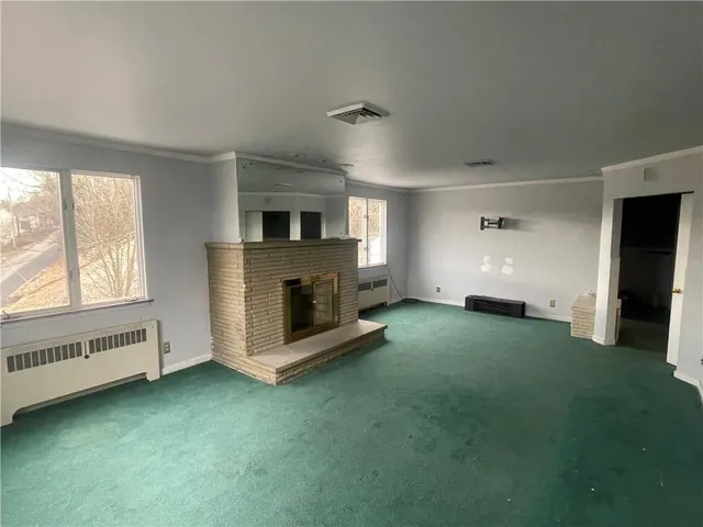 an empty room with a fireplace and window