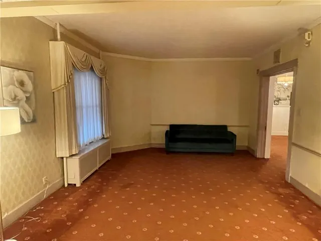a living room with a couch and a stove next to a window