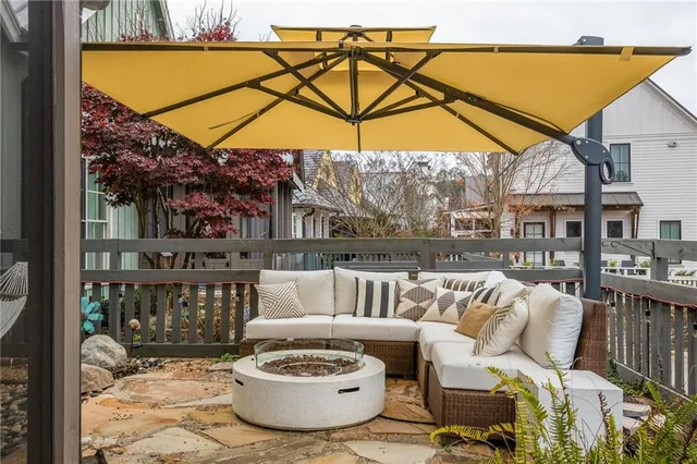 a view of a patio with table and chairs under an umbrella with a small yard