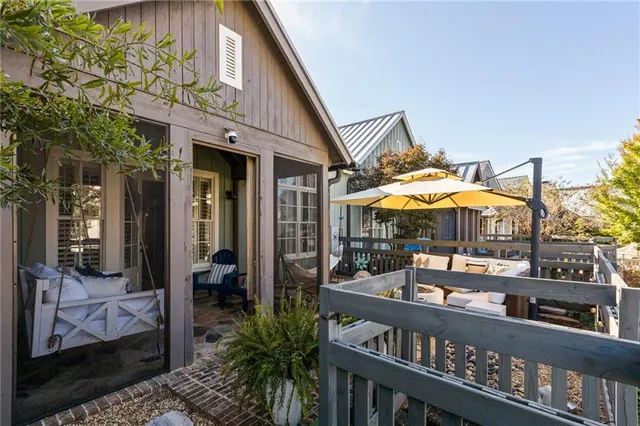 a view of a patio with table and chairs under an umbrella with a small yard