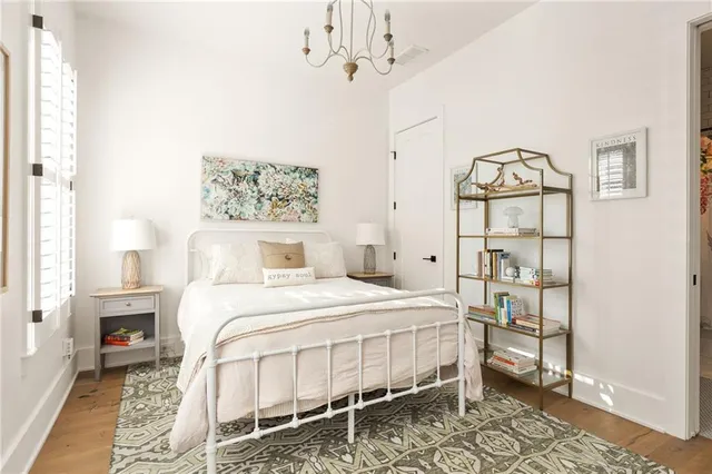 a bedroom with a bed a table and painting on the wall