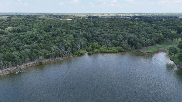 an aerial view of a residential houses with outdoor space and lake view