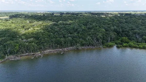 an aerial view of residential houses with outdoor space and lake view