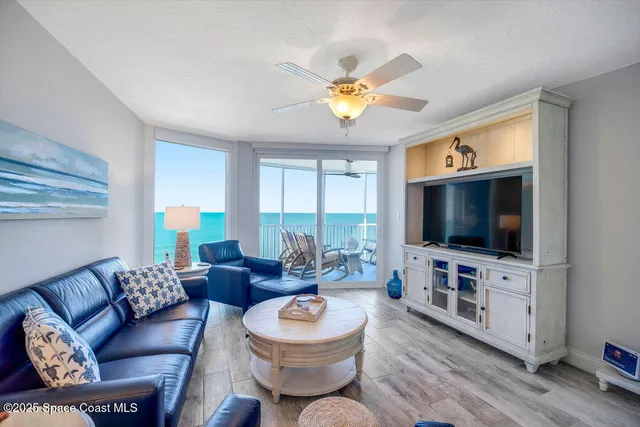 a living room with furniture a flat screen tv and a window