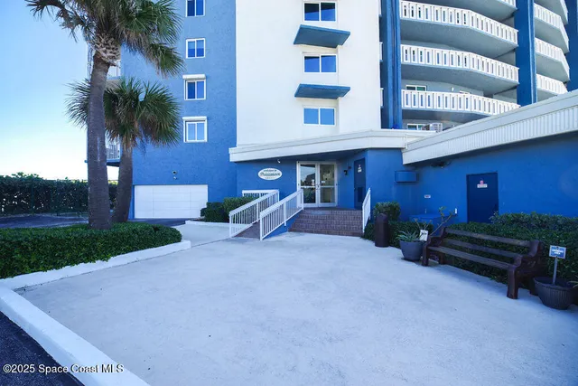 a view of a building with a yard and furniture