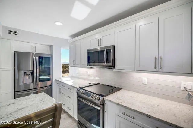 a kitchen with granite countertop cabinets stainless steel appliances and wooden floor