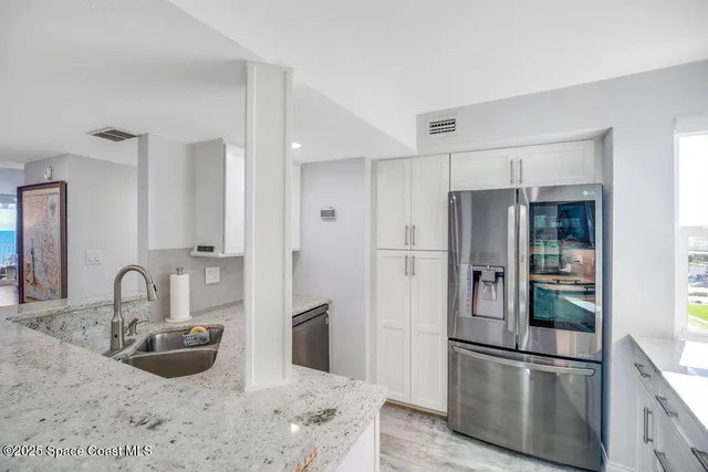a kitchen with stainless steel appliances granite countertop a refrigerator and a sink