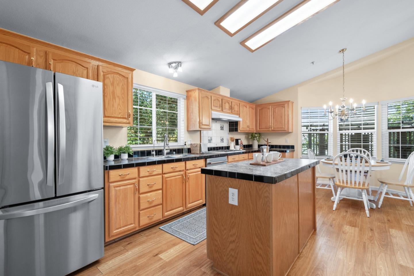 552 Bean Creek Road Scotts Valley, CA 95066 - Photo 30 of 76 a kitchen with stainless steel appliances granite countertop a refrigerator a sink dishwasher a stove and a dining table with wooden floor