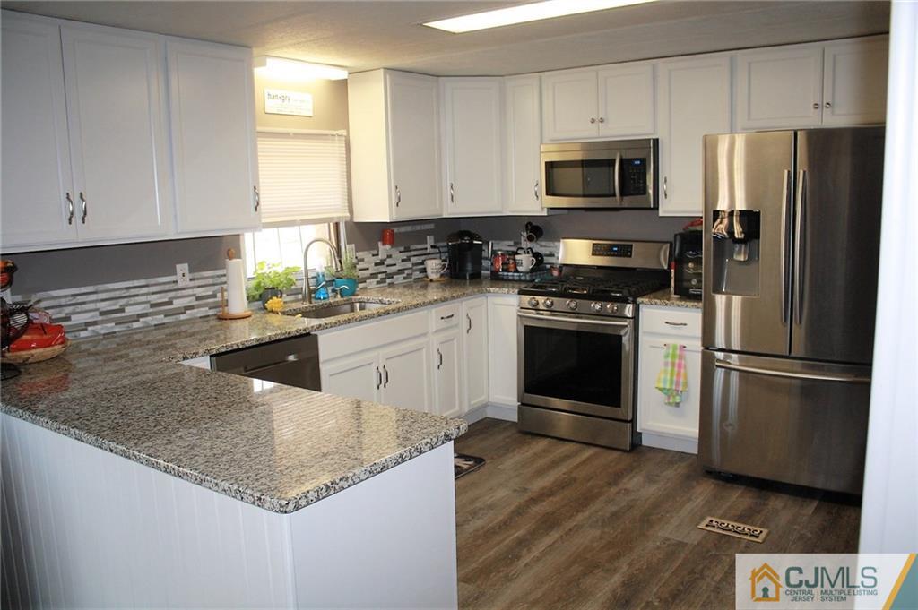 2 Hugo Road North Brunswick, NJ 08902 - Photo 2 of 14 a kitchen with a sink a microwave a refrigerator and cabinets
