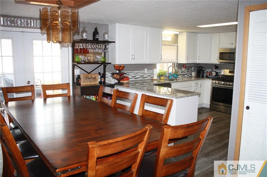 2 Hugo Road North Brunswick, NJ 08902 - Photo 3 of 14 a dining table with chairs and kitchen view