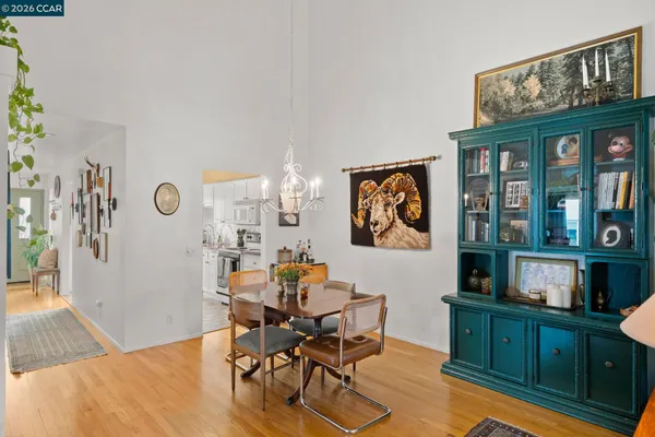 a dining room with wooden floor and a chandelier