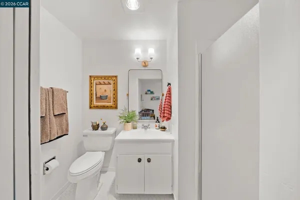 a bathroom with a sink vanity mirror and toilet