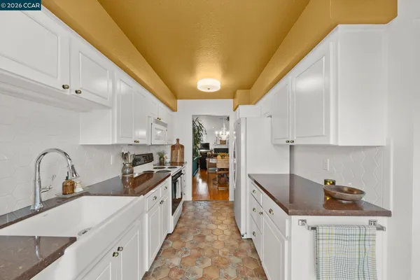 a kitchen with granite countertop a sink stove and cabinets