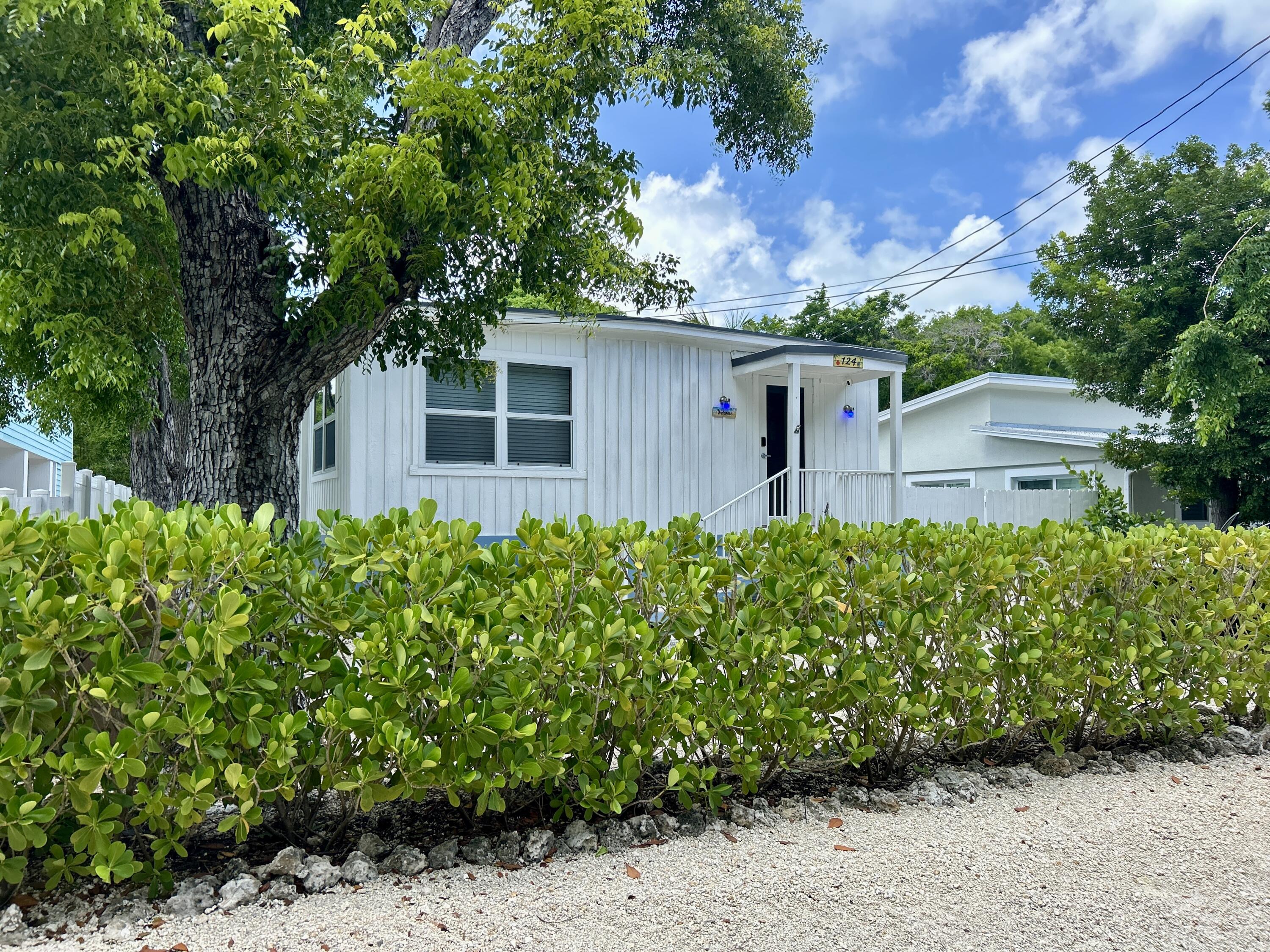 124 South Bay Harbor Drive Key Largo, FL 33037 - Photo 2 of 43 a front view of a house with a yard
