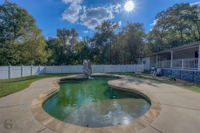 a view of a backyard with swimming pool