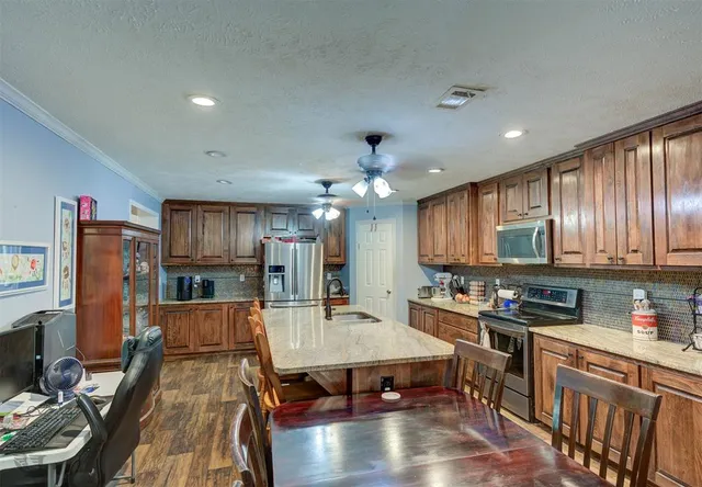 a kitchen with stainless steel appliances granite countertop a stove refrigerator sink microwave and cabinets