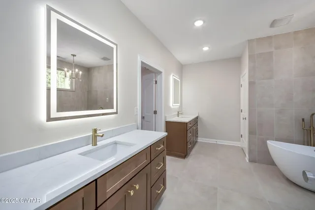 a bathroom with a granite countertop bathtub shower and toilet