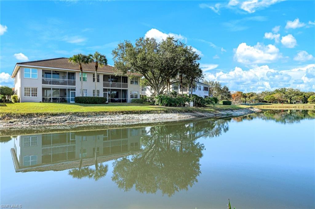 2033 Crestview Way, Unit 104 Naples, FL 34119 - Photo 17 of 24 a view of a lake with a house in the background