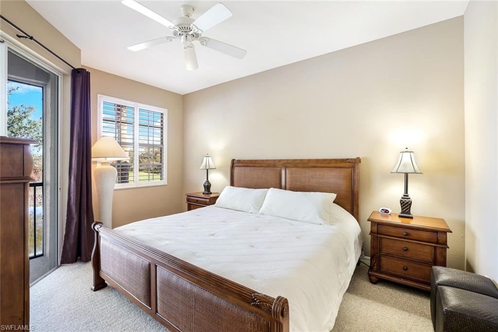2033 Crestview Way, Unit 104 Naples, FL 34119 - Photo 8 of 24 a bedroom with a bed and a chandelier