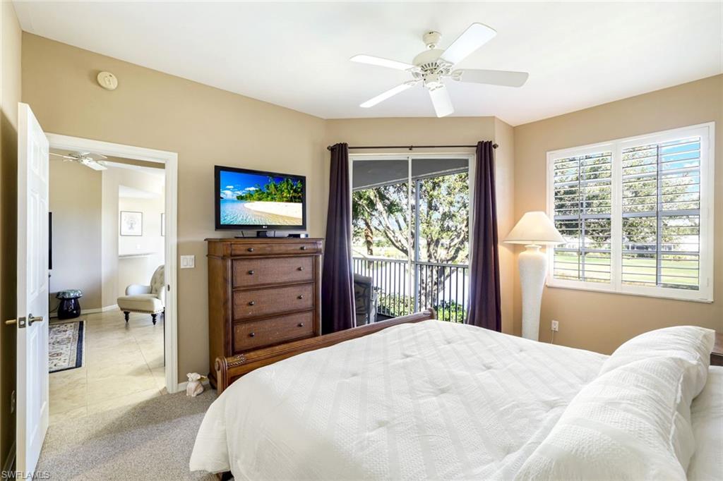 2033 Crestview Way, Unit 104 Naples, FL 34119 - Photo 9 of 24 a bedroom with a bed dresser and a flat tv screen