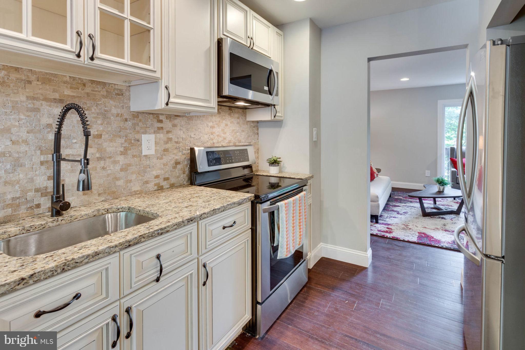 2349 Southgate Square Reston, VA 20191 - Photo 11 of 30 a kitchen with stainless steel appliances granite countertop a sink stove and microwave