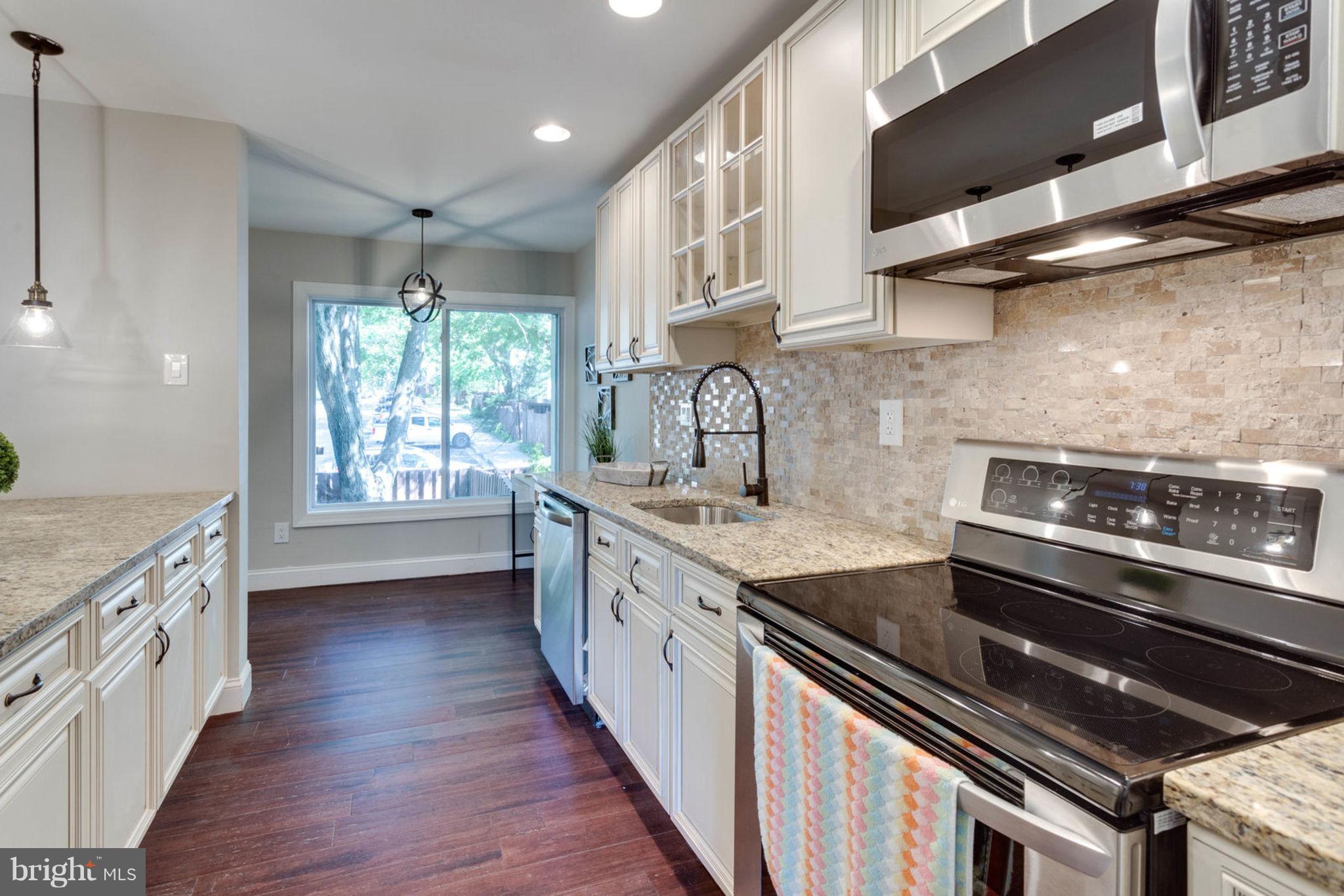 2349 Southgate Square Reston, VA 20191 - Photo 12 of 30 a kitchen with stainless steel appliances granite countertop a sink a stove and a wooden floors