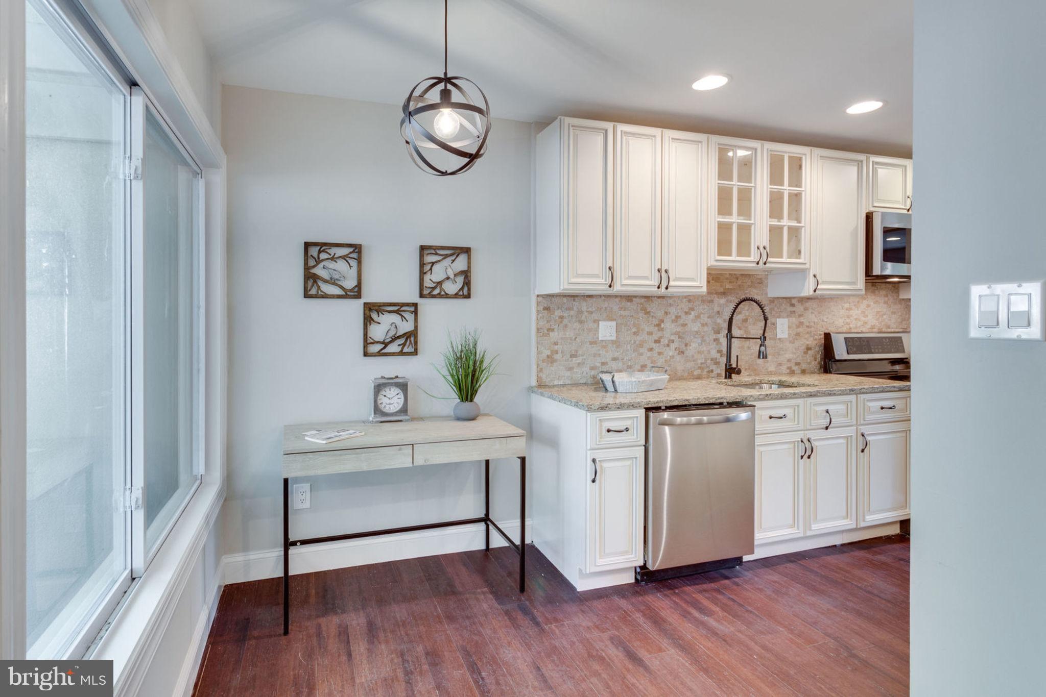 2349 Southgate Square Reston, VA 20191 - Photo 6 of 30 a kitchen with stainless steel appliances granite countertop a sink a stove a refrigerator and white cabinets with wooden floor