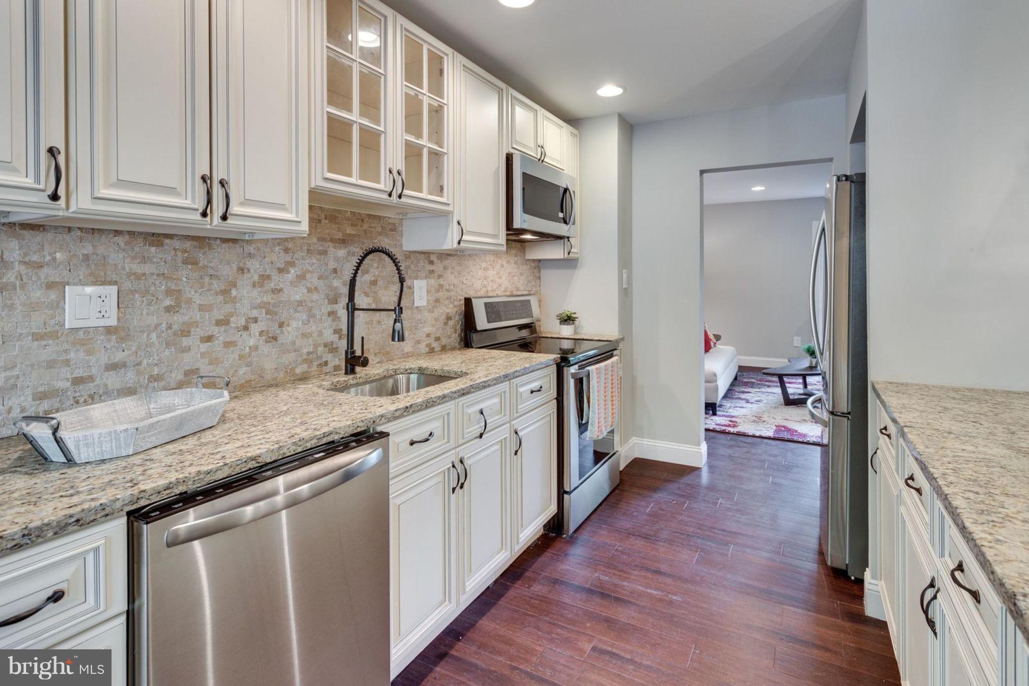 2349 Southgate Square Reston, VA 20191 - Photo 9 of 30 a kitchen with granite countertop a sink stainless steel appliances and cabinets