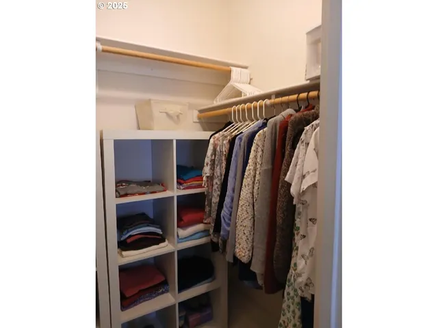 a view of walk in closet with clothes and shoes