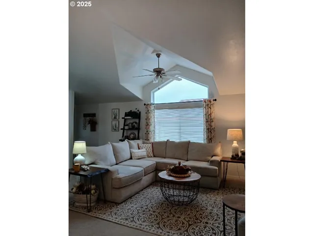 a living room with furniture and a ceiling fan